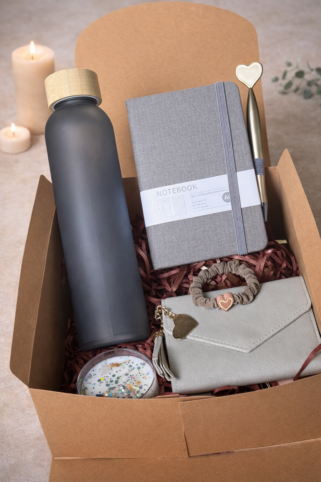 geschenkbox mit trinkflasche, kerze, geldbeutel, stift, notizblock